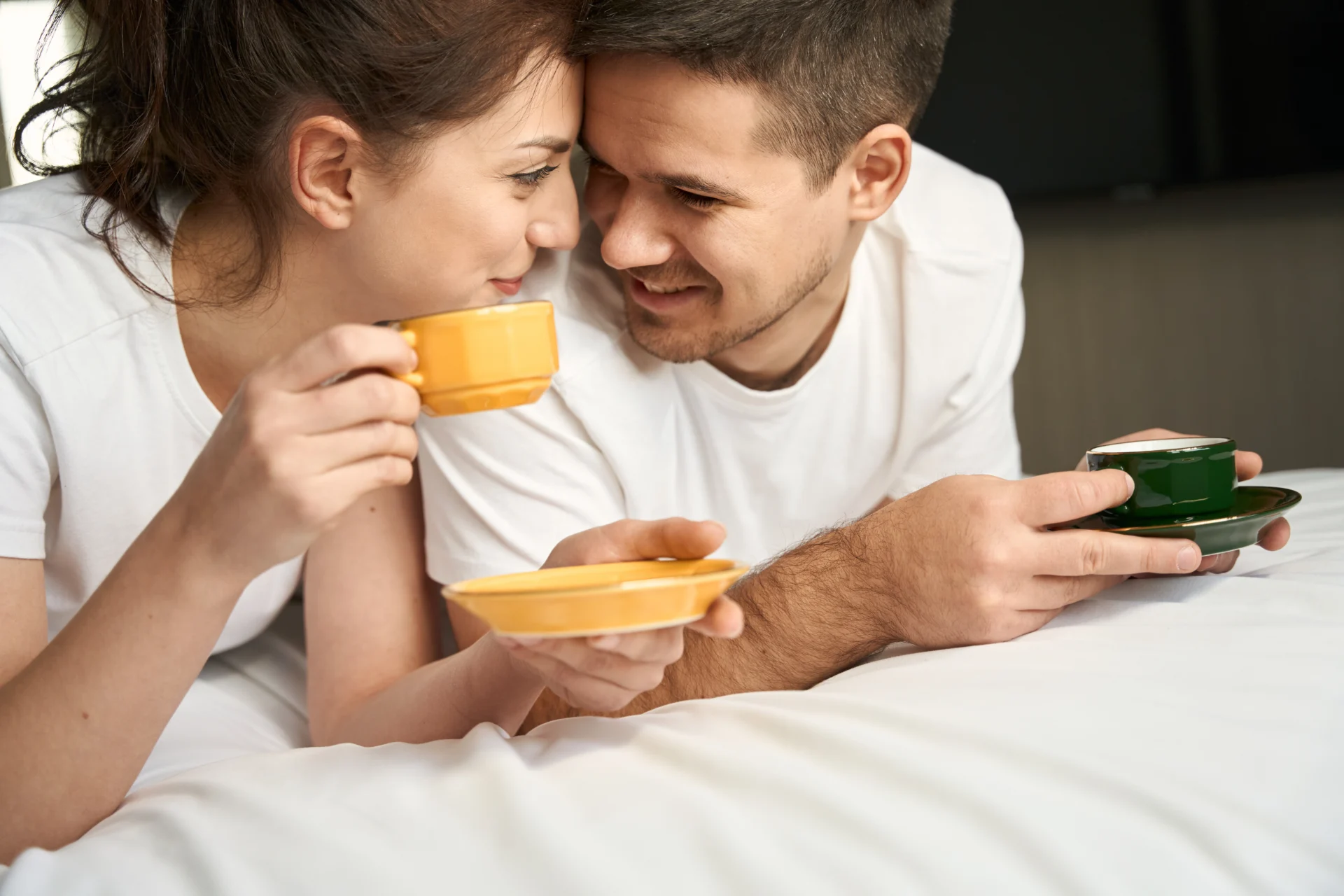 Ein Paar entspannt gemeinsam bei einer Tasse Kaffee im Bett