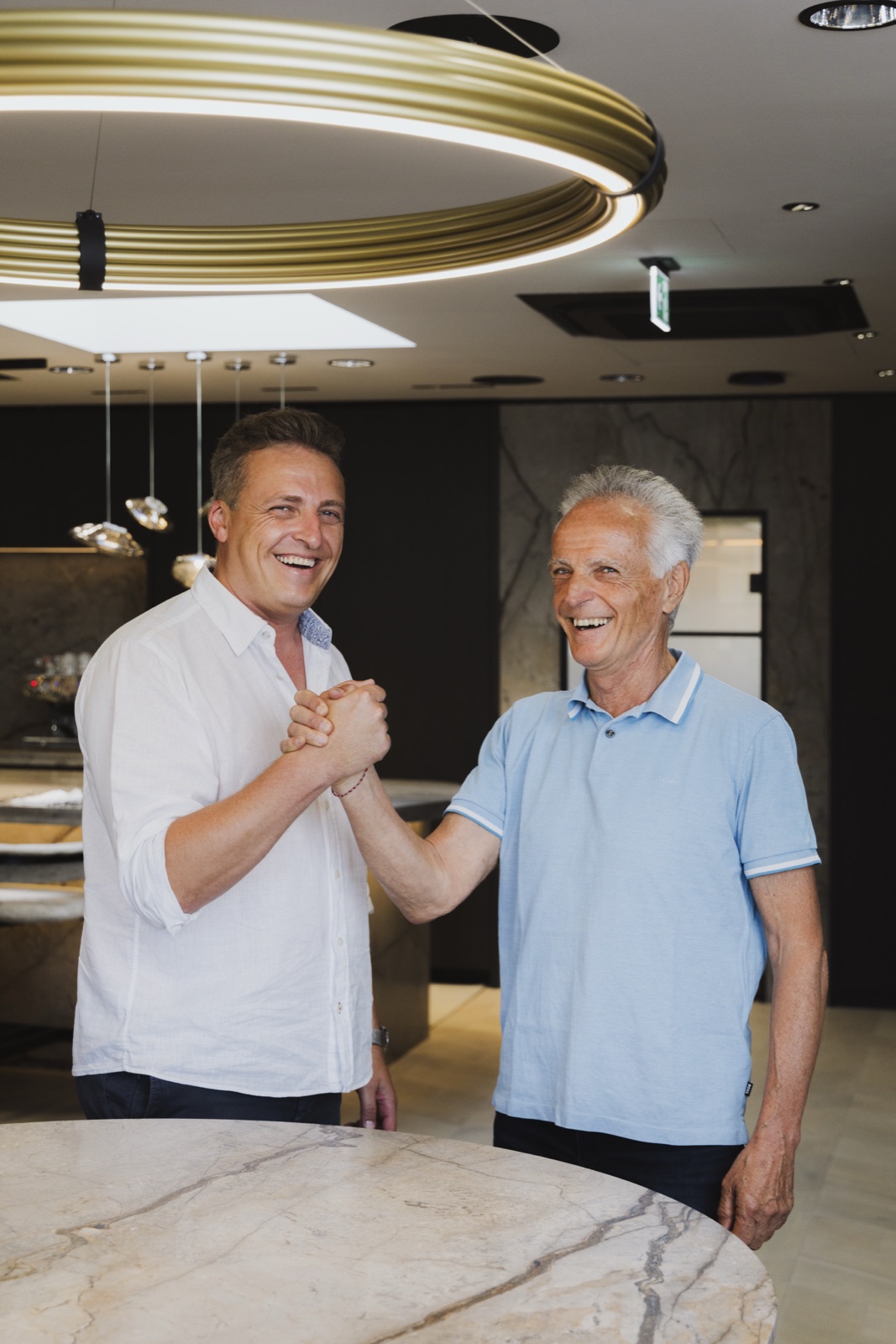 Vater und Sohn Schwarzhans beim Handschlag im Schauraum von Wohnfloor